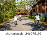 Small photo of Traveler teenager ride a bicycles in parks under the umbrage