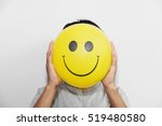 A man holding yellow balloon with smile face emotion instead of head. Positive Thinking concepts. hiding some bad feeling just keep smiling