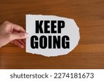 Keep going. Woman hand holds a piece of paper with a note. The way forward, continuity, motivation, positive emotion, inspiration and encouragement.