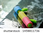 Small photo of colorful Pump water gun on wet pool side bar