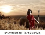 Warrior wearing iron helmet and red cloak.