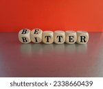 Better or bitter symbol. Concept word Better and Bitter on wooden cubes. Beautiful grey table red background. Business and better or bitter concept. Copy space.