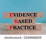 Small photo of Text EBP Evidence-based practice concept on brick blocks. Beautiful blue background, wooden table. Business concept.