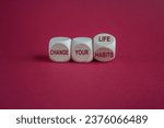 Small photo of Turned a cube and changes the slogan change your habits to change your life. Beautiful red background. Copy space. Business and change concept.