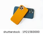 Modern mobile phones in blue and yellow leather cases on a white background. Modern smartphones with triple lens cameras