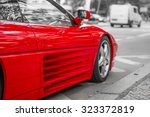 Red sports car on city streets, black and white background