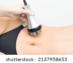Small photo of procedure removing cellulite on female abdomen, cavitation belly massage. Ultrasonic massage for weight loss. Correction of female figure without surgical intervention. Closeup of the tummy.