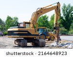 Small photo of Hydraulic crusher excavator backhoe machinery working on site demolition stone crusher
