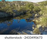 Small photo of Watercourse between beautiful rocks, and dark waters with lots of vegetation around, located in the rural region of Tres Barras, municipality of Serro, Minas Gerais, Brazil.