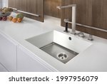Small photo of Modern kitchen with white furniture and white worktop have undermount kitchen sink and Tap water in the kitchen. white tone and clean kitchen.