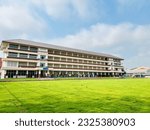 Small photo of A vast school with a blue sky, the lawn contrasts with the school and the sky.