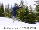 Little boy jumping on downhill skis in forest. Skiing between trees. Adrenaline sport in winter
