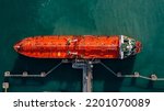 Aerial view oil ship tanker vessel loading and unloading in oil terminal station refinery, Global business import export logistic transport sea freight cargo tanker, Red crude oil tanker ship at port.