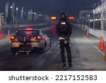 Small photo of Dragster driver with drag car in race track at night, Drag racing car at the start competition at night, Drag race car in race track at night, Sport car at the start, speed competition.