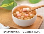 Small photo of Little red and white tangyuan (tang yuan, glutinous rice dumpling balls) with sweet syrup soup in a bowl for Winter solstice festival food.