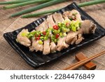 Delicious sliced chicken with scallion oil sauce on wooden table, close up.