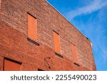 Old brick wall with brick filled windows. Red brick wall a factory with four bricked up windows with space for text. House brick wall. Street photo, nobody