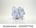 Blank crumpled sheet of paper forming a ball isolated on a white background.