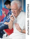 Small photo of Senior man with chest pain taking nitroglycerin