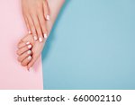 Stylish trendy female manicure. Beautiful young woman's hands on pink and blue background.