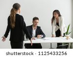 Small photo of Diverse colleagues arguing about unpunctuality in office, coworkers looking at wristwatch blaming tardy employee for being late at meeting, bad time management, business team missed deadline concept