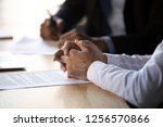 Small photo of Lawyer solicitor with clasped hands consulting client about document making financial legal deal sell law services, close up view of business counselor or agreement party at contract signing concept