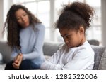 Small photo of Mom or psychologist talking counseling upset offended african american child girl feels sad insulted, sulky frustrated black mixed race kid daughter having psychological trauma depression problem