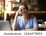 Small photo of Businesswoman or student girl sitting at table near pc feels stressed confused facial expressions, having head ache, forgot important thing, missed an appointment made mistake in work or study concept