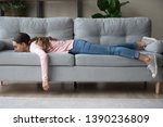 Full length of girl lying rest at home in living room buried her face in couch feels exhaustion having day nap lack of energy after party sleepless night or overworked, too tired no motivation concept