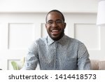 Happy cheerful young black man video calling looking at camera at home, smiling african guy communicate in internet chat recording vlog talking laughing enjoy online conversation, webcam view