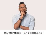 Thoughtful african guy thinking try solve problem pose isolated on grey studio background, worried black man in glasses feels concerned puzzled lost in thoughts pondering making decision concept image