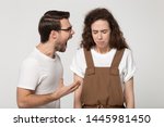 Small photo of Young unhappy couple isolated on grey studio background, mad angry guy open mouth screaming at girlfriend, girl standing desperate listening aloud yelling feels weak abused crying unable to fight back
