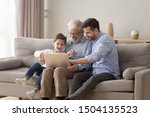 Happy three 3 age multi generation men family old grandfather young adult grown son father and child boy grandson having fun using laptop computer spend time browsing internet at home sit on sofa