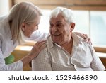 Small photo of Caring middle-aged female licensed practical nurse in white coat talk to elderly patient 80s man, worker care about old healthcare consumer listens complaints give support, caregiving service concept