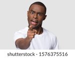 Crazy angry African American man pointing finger, looking at camera, mad young male quarreling, blaming anybody, shouting, feeling aggression, conflict concept, isolated on studio background