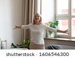 Happy mature female pensioner stand with arms open feel positive excited welcoming new good day, smiling senior middle-aged woman have fun satisfied with life, enjoy weekend leisure time