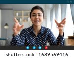 Small photo of Headshot portrait screen view of smiling young Indian woman sit at home talk on video call with friend or relative, happy millennial biracial female speak online using Webcam conference on computer