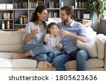 Small photo of Happy young couple parents teaching little preschool daughter drinking clear water every day. Smiling healthy family holding glasses with pure aqua, enjoying morning daily healthcare habit at home.
