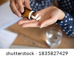 Small photo of Top above close up view woman pours out from bottle pills into palm. Female takes daily meds complex vitamins for healthy skin nails and hair. Effective treatment, remedy pain killer drugs concept