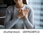 With all my heart! Close up of young lady hands folded close to heart in peaceful candid sincere sign gesture appreciating destiny god for help, expressing heartfelt thank you to friend mate colleague