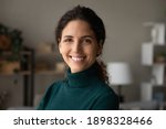 Small photo of Close up portrait of smiling young Caucasian woman look at camera feel excited optimistic. Happy millennial 20s female renter or tenant overjoyed moving relocating to new home or apartment.