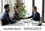 Small photo of Happy business partners shaking hands, greeting or making successful great commercial deal after successful negotiations, smiling diverse employees sitting at table in modern boardroom, acquaintance