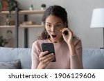 Head shot emotional young woman looking at smartphone screen with opened mouth, feeling surprised with received offer. Amazed millennial lady getting sms with unbelievable news. shocked by sale prices