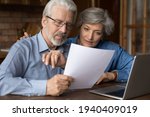 Small photo of Every paper needs attention. Interested old age married couple do paperwork engaged in reading document. Focused retired spouses study terms conditions of insurance policy think on signing agreement