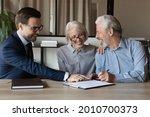 Small photo of Happy senior couple signing medical insurance agreement, real estate lease contract in agent office. Elderly man and woman filling paper form, meeting with lawyer, solicitor, broker, realtor