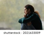 Side view frustrated thoughtful woman looking out rainy window in distance alone, lost in thoughts, upset unhappy young female feeling lonely and depressed, thinking about relationship problems