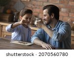 Small photo of Well done my boy. Happy father bump fists with preteen son greet smart child with getting victory winning game of draughts. Overjoyed young dad tween kid celebrate end of interesting match of checkers