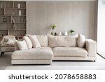 Fashion furniture inside modern light living room with white sofa, built-In bookcase with shelves, armchair, no people. Design interior ideas, furnishing store, new real-estate, rent property concept