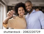 Small photo of Happy Black millennial couple showing keys, smiling at camera, hugging. Husband and wife, new homeowners, tenants excited with house buying, real estate property purchase, renting apartment. Close up