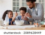 Small photo of Loving African dad teach kids to cook in kitchen, hold beaters mixing ingredients in bowl preparing dough for cookies, parent share family recipe to preschool son and daughter. Hobby, cookery concept